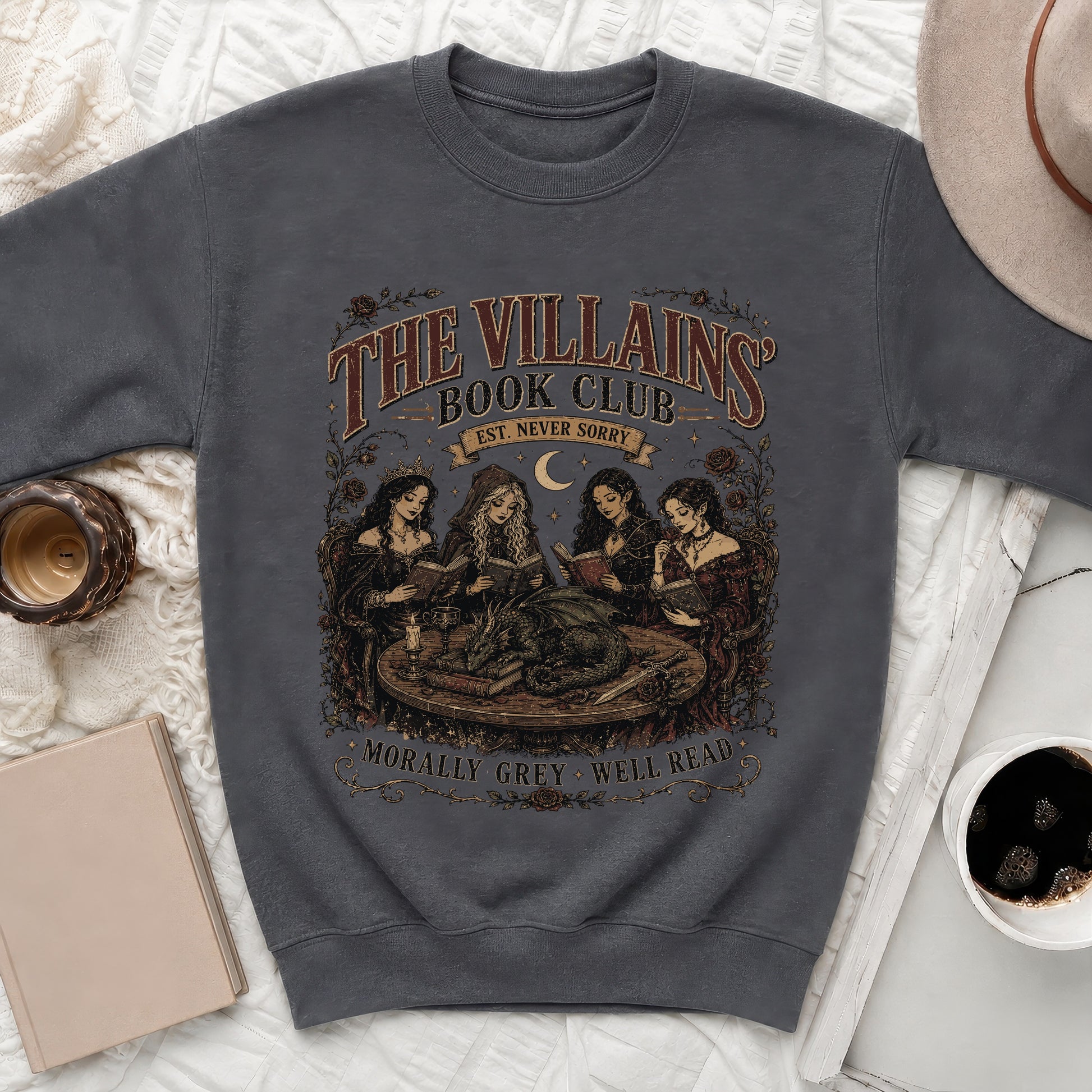 Dark grey sweatshirt with "The Villains Book Club" graphic featuring witches reading to a dragon and text.