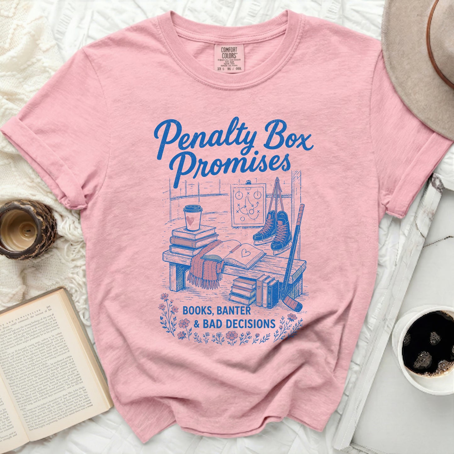 Pink t-shirt with "Penalty Box Promises, Books, Banter & Bad Decisions" graphic.