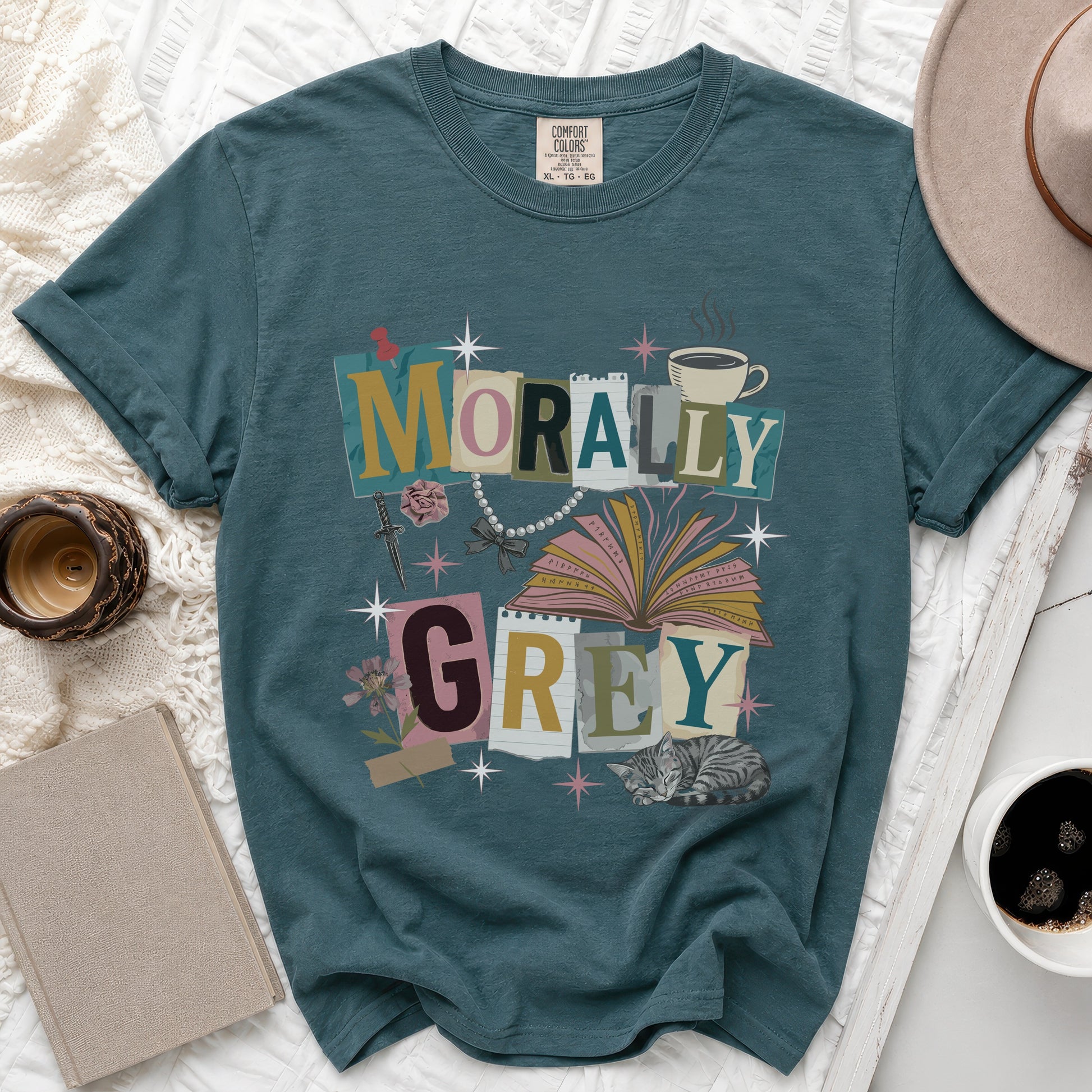 Teal t-shirt with "MORALLY GREY" text collage, cat, and book.