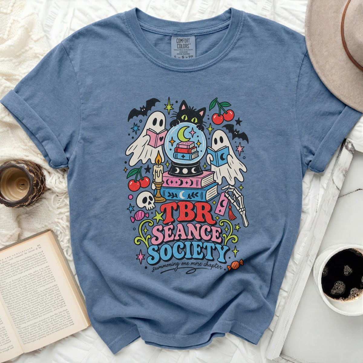 Blue t-shirt with "TBR SEANCE SOCIETY" text and a spooky book-themed graphic.