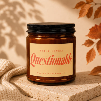 Amber candle with "SPICE LEVEL: Questionable" and "MAGICMERCH`EMPORIUM" text.