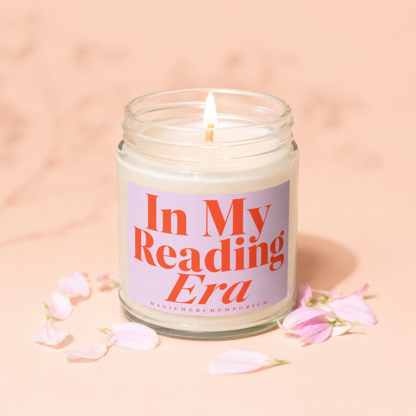 Lit candle in a glass jar with "In My Reading Era" text and pink petals.