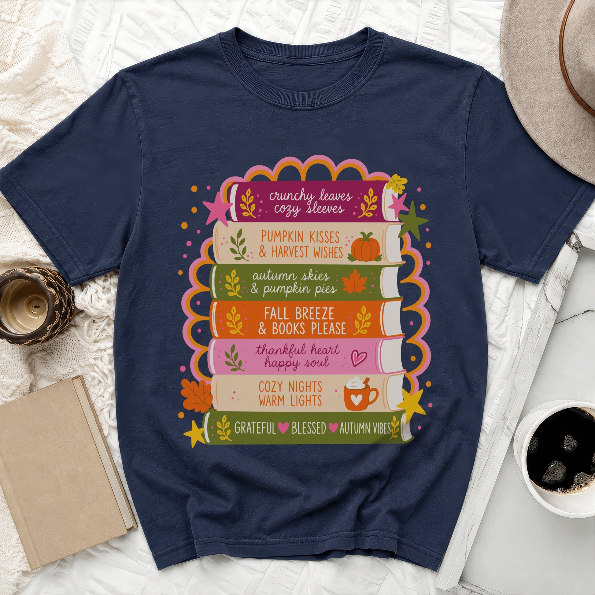 Navy t-shirt with stacked books design saying "crunchy leaves cozy sleeves" and more.