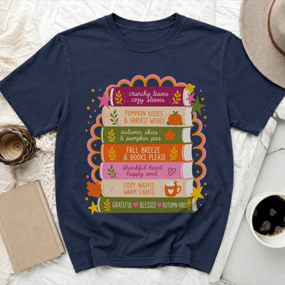 Navy t-shirt with stacked books design saying "crunchy leaves cozy sleeves" and more.
