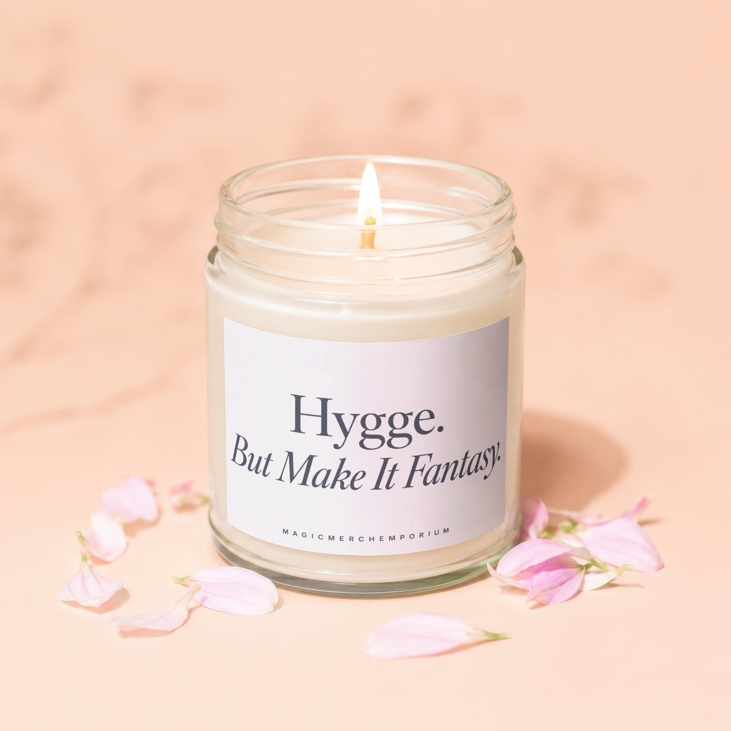 Jar candle with lit wick and label reading "Hygge. But Make It Fantasy."