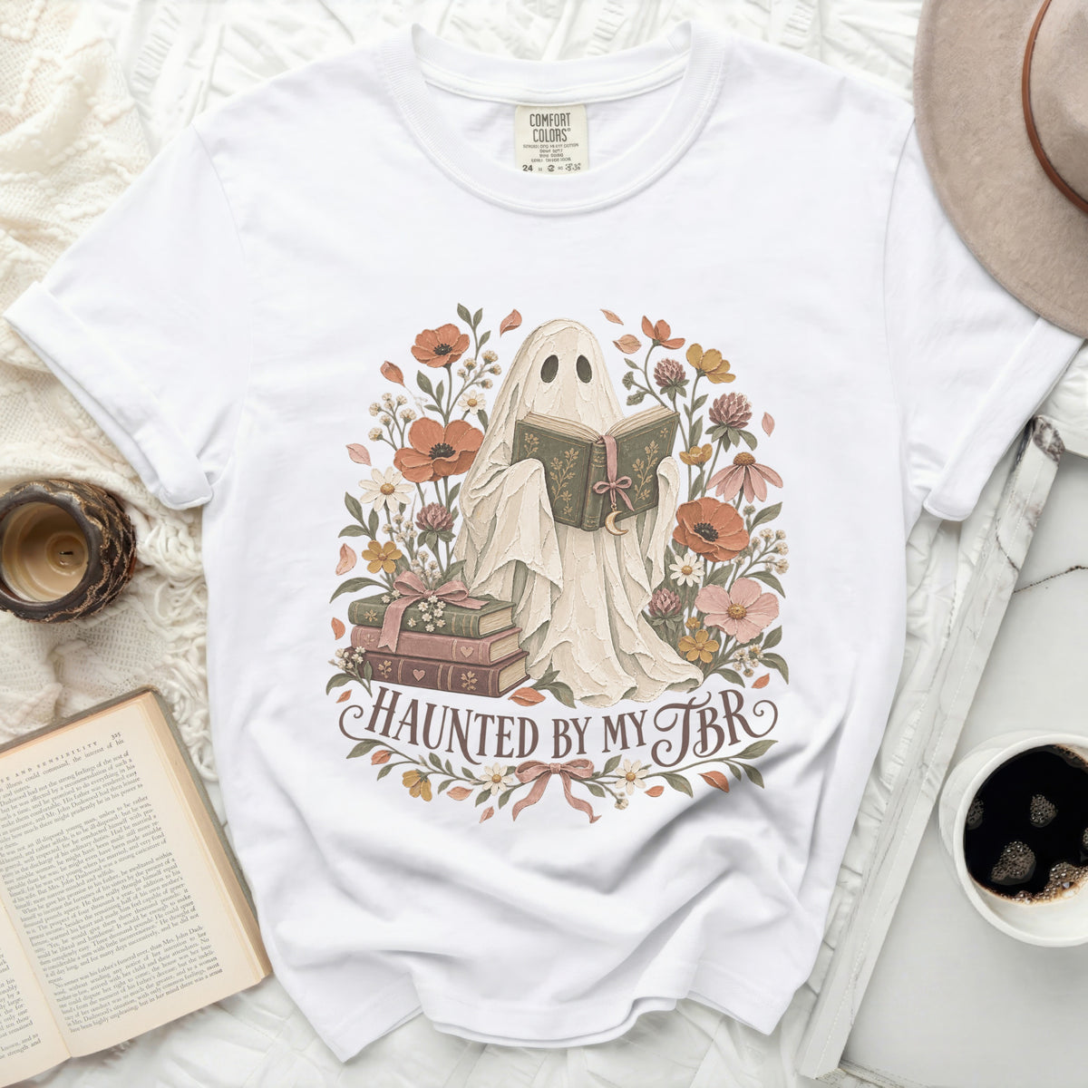 Ghost reading a book surrounded by flowers with text "Haunted by my TBR".