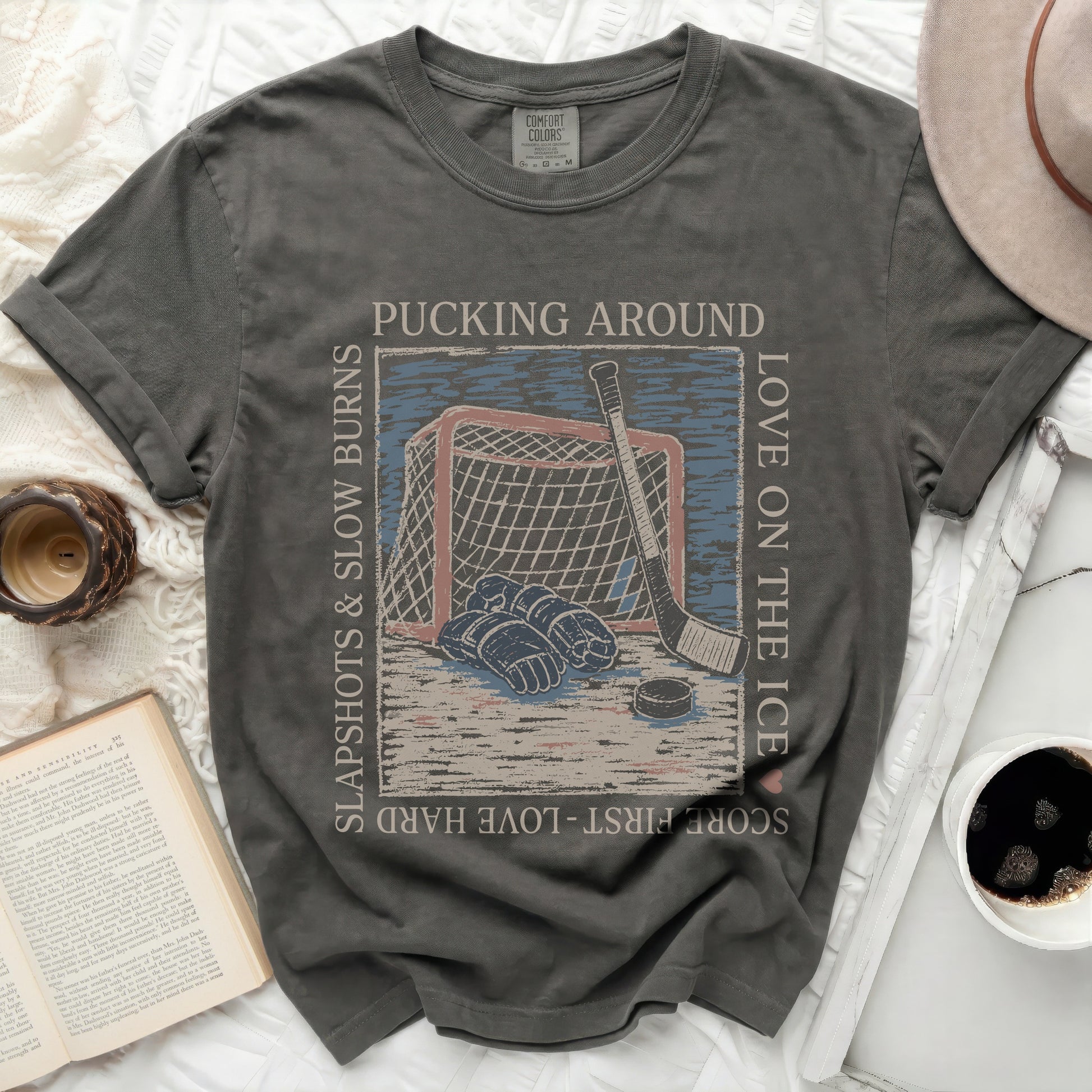 Dark grey t-shirt with hockey puck, net, and text "Pucking Around Love on the Ice".