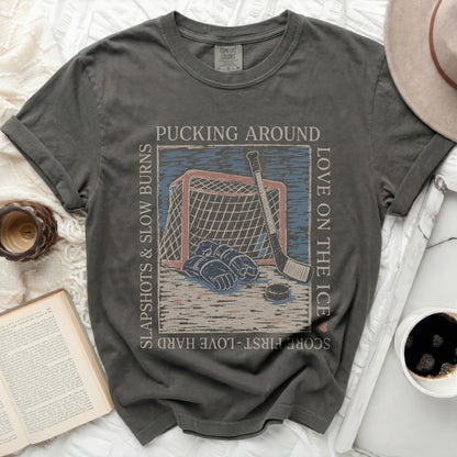 Dark grey t-shirt with hockey puck, net, and text "Pucking Around Love on the Ice".