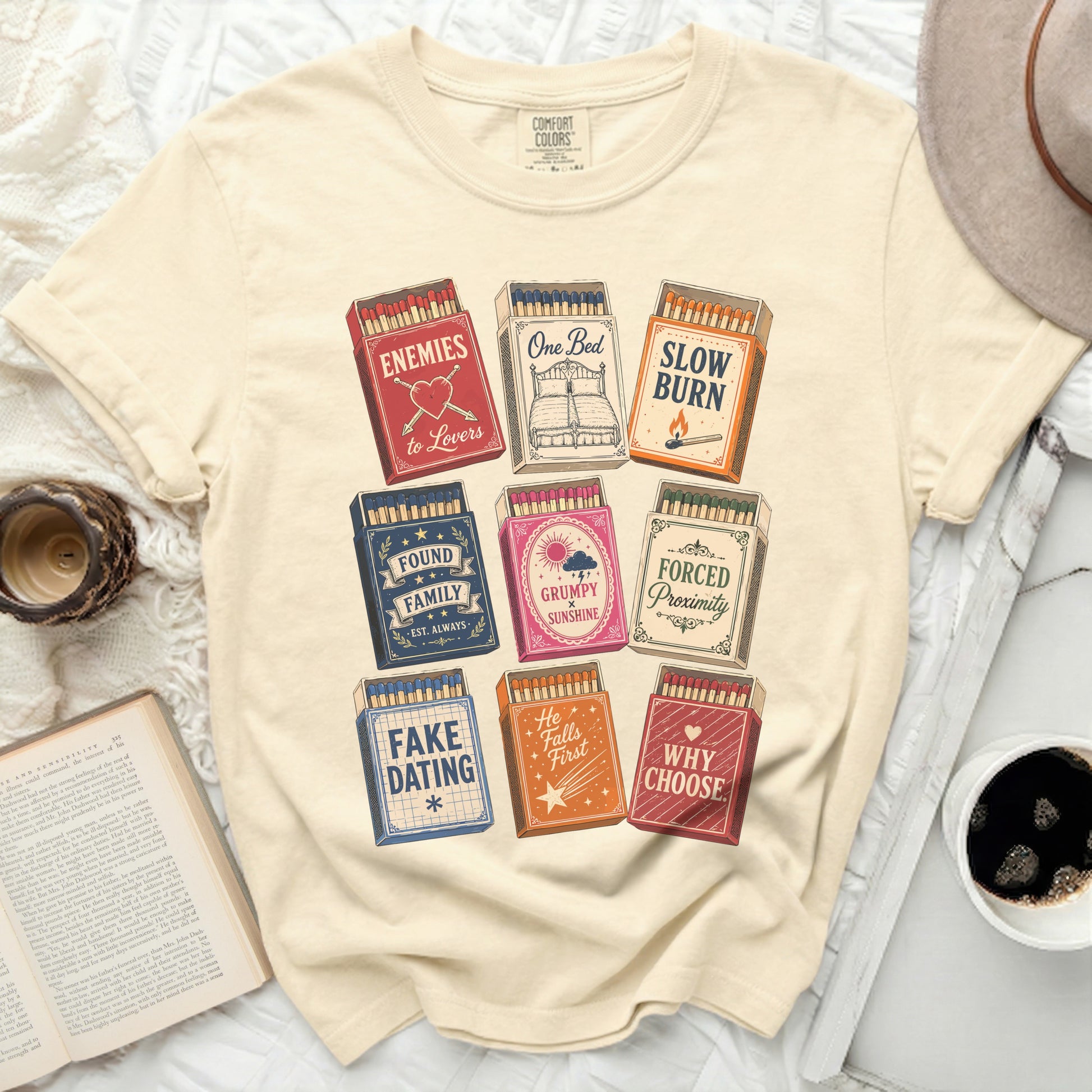 Cream t-shirt with nine matchboxes featuring book titles and phrases.