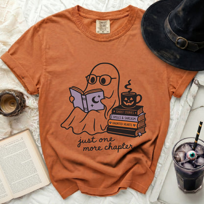Orange t-shirt with ghost reading book and "just one more chapter" text.