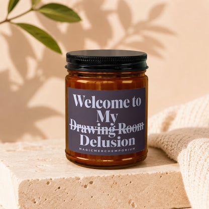 Amber candle jar labeled "Welcome to My Drawing Room Delusion" and "MAGICMERCH.EMPORIUM".