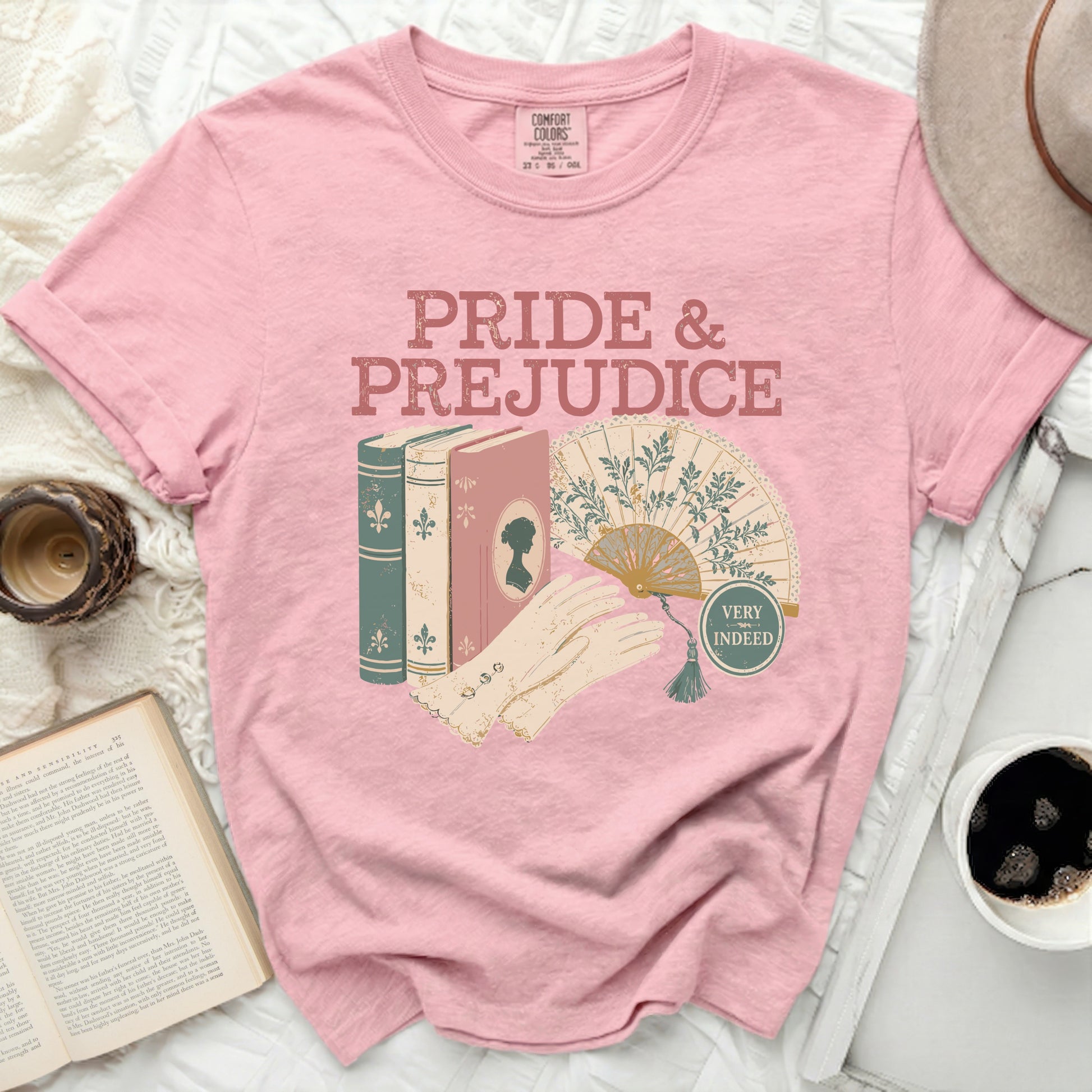 Pink t-shirt with "Pride & Prejudice" text, books, fan, and gloves.