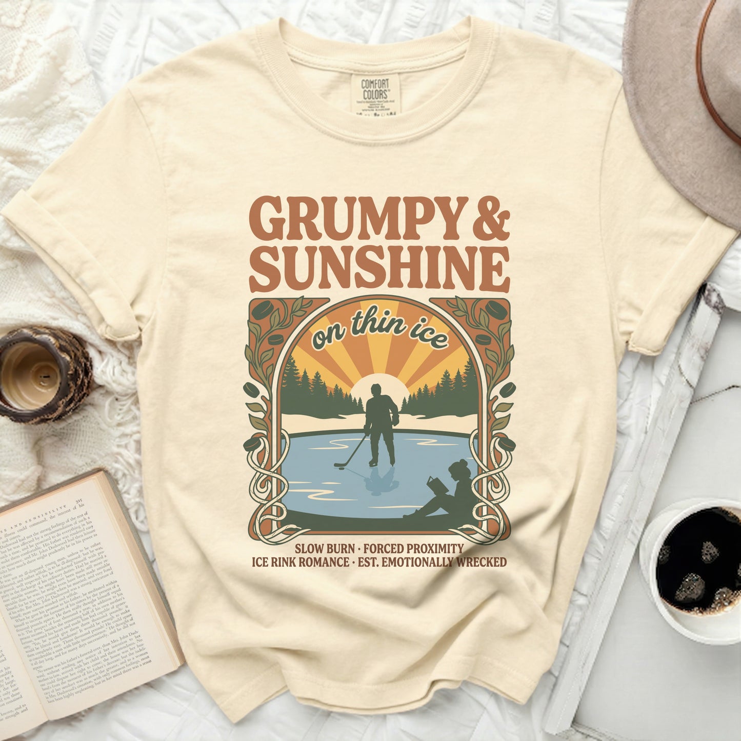 Cream t-shirt with "Grumpy & Sunshine on Thin Ice" text and ice skating illustration.