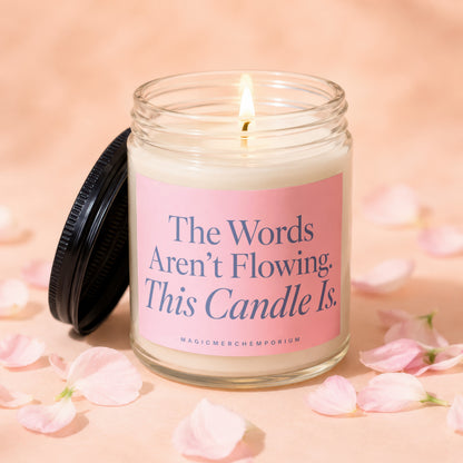 Jar candle with pink label reads "The Words Aren't Flowing. This Candle Is."