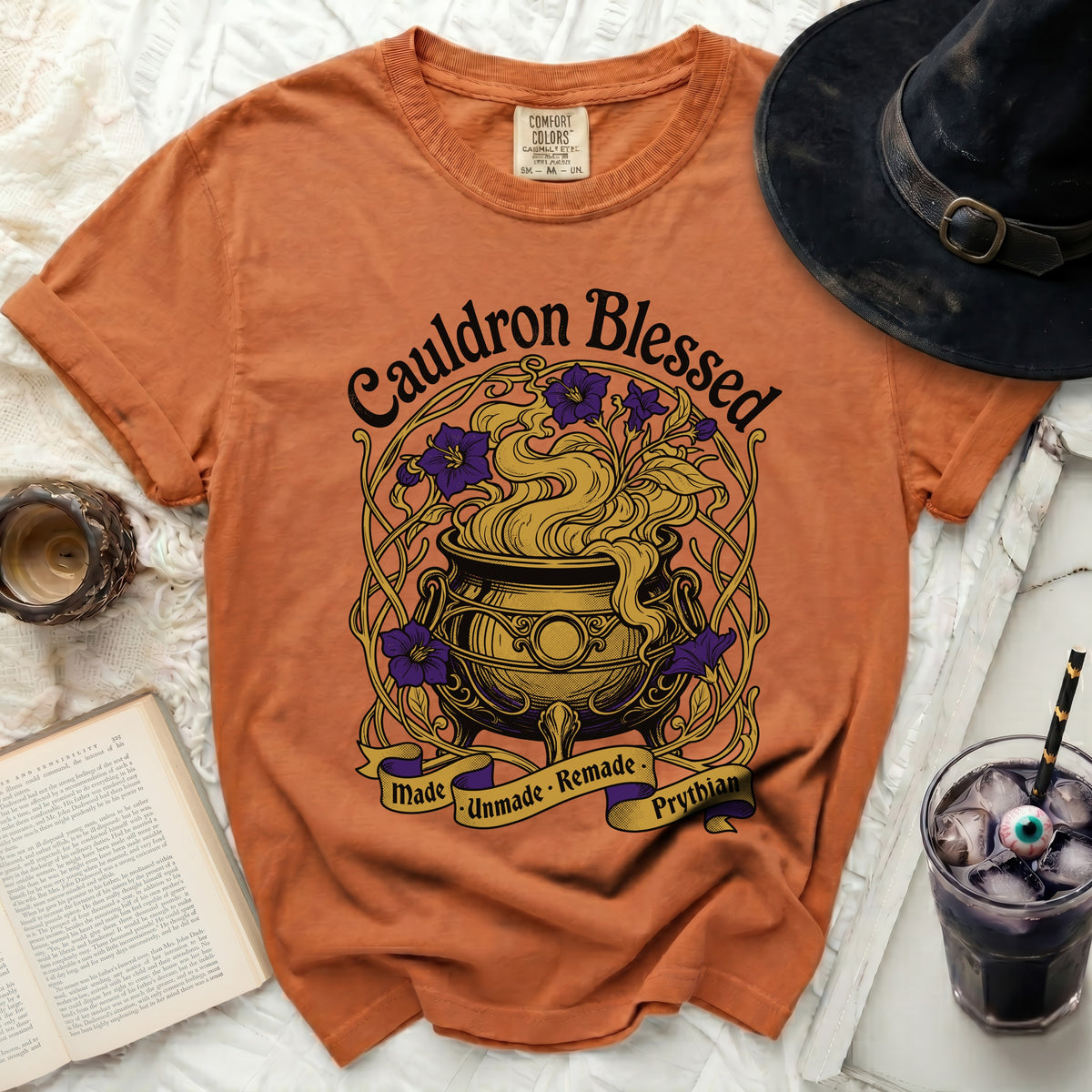 Orange Comfort Colors t-shirt with "Cauldron Blessed Made Unmade Remade Prythian" graphic.