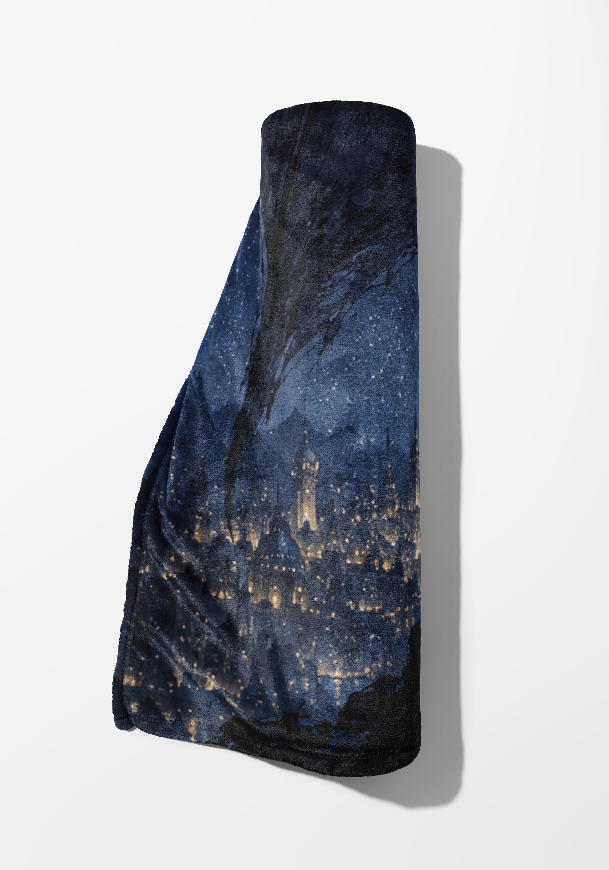 Rolled dark blue blanket with a starry night sky and illuminated cityscape pattern.