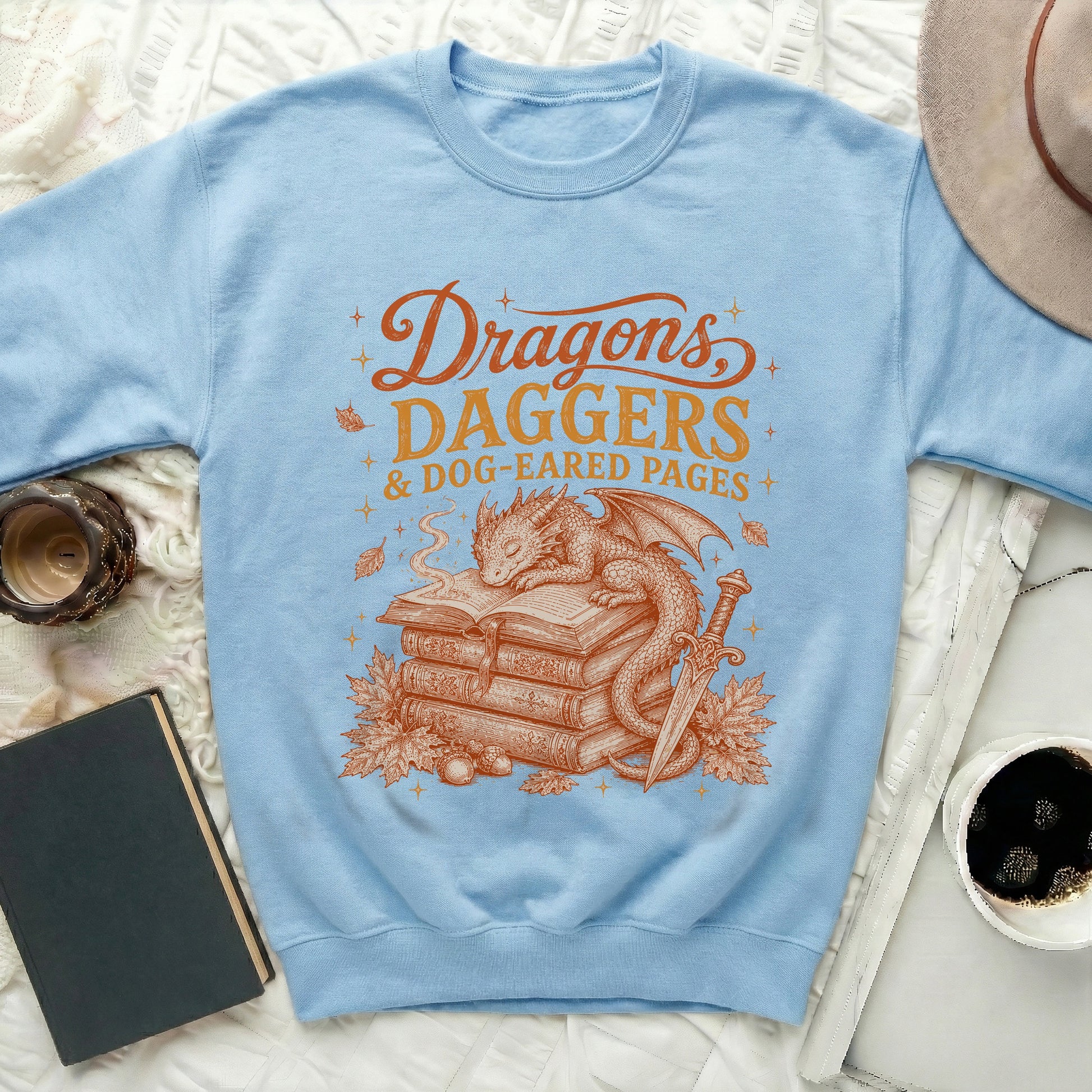 Light blue sweatshirt with "Dragons, Daggers & Dog-Eared Pages" graphic.