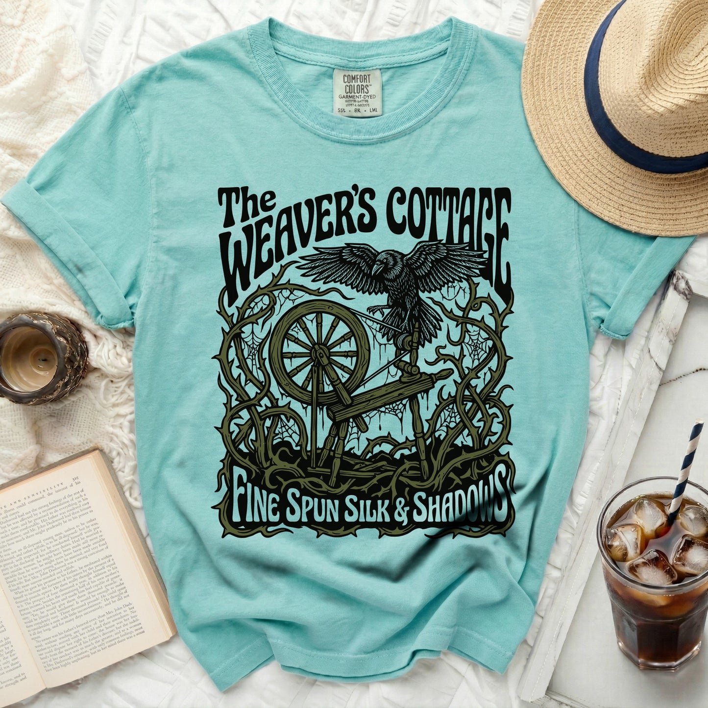 The Weaver's Cottage t-shirt with raven, spinning wheel, and text.