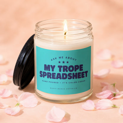 Jar candle with teal label that reads "My Trope Spreadsheet" and "Hand Poured + It's Color-Coded".