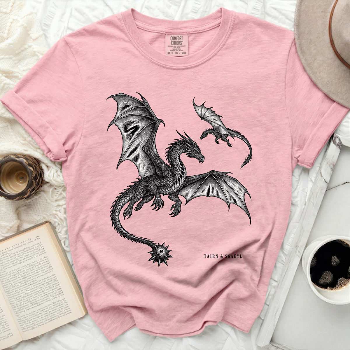 Pink t-shirt with black detailed dragon print and "TAIRN & SGAEYL" text.