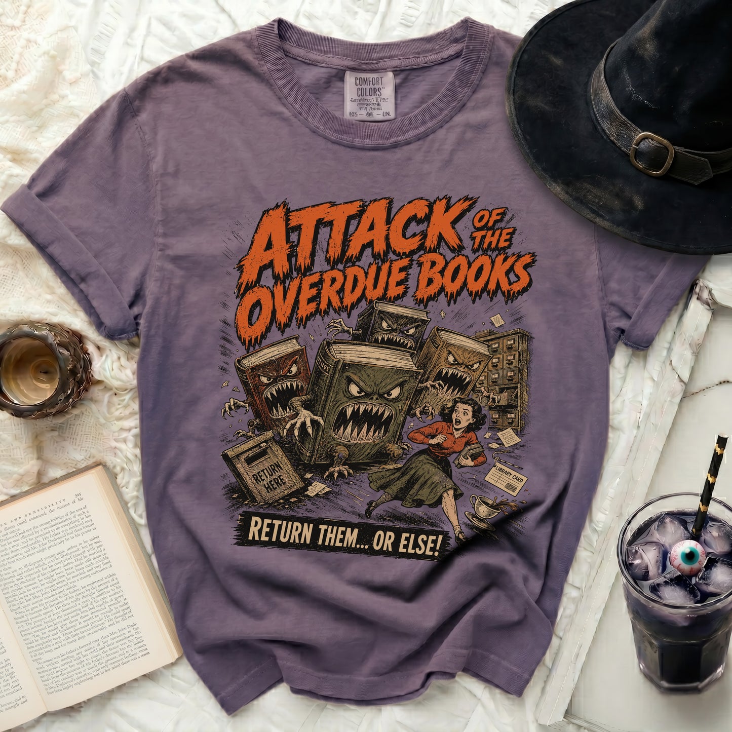 Purple t-shirt with "Attack of the Overdue Books" Halloween graphic.