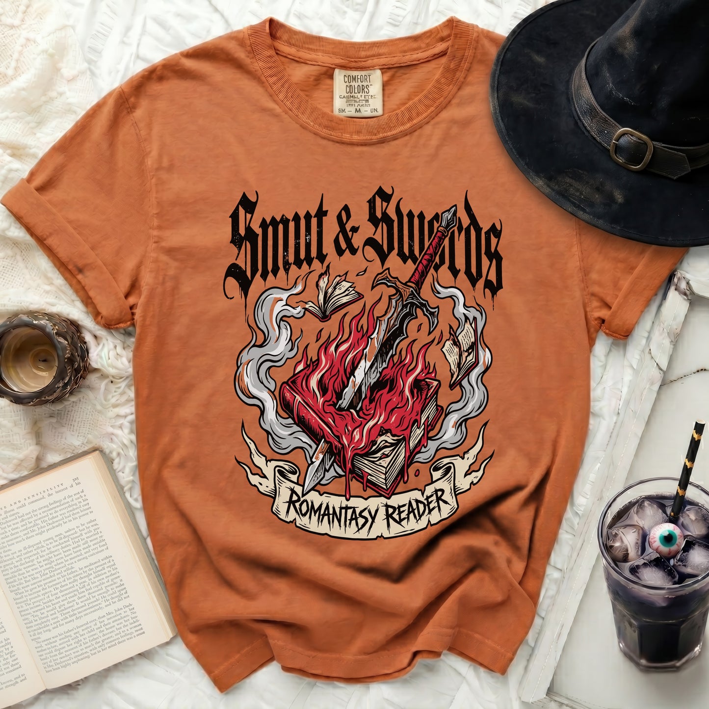 Orange t-shirt with "Smut & Swords Romantasy Reader" graphic on a book.