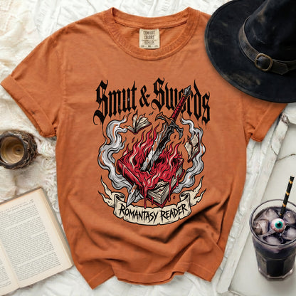 Orange t-shirt with "Smut & Swords Romantasy Reader" graphic on a book.