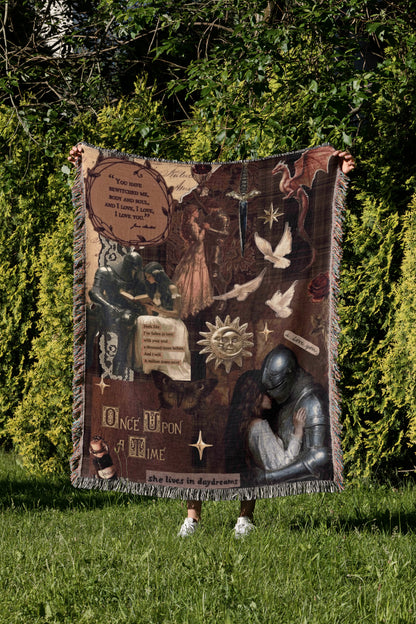 a person standing in a grassy area, holding a large blanket that is decorated with various images and text.