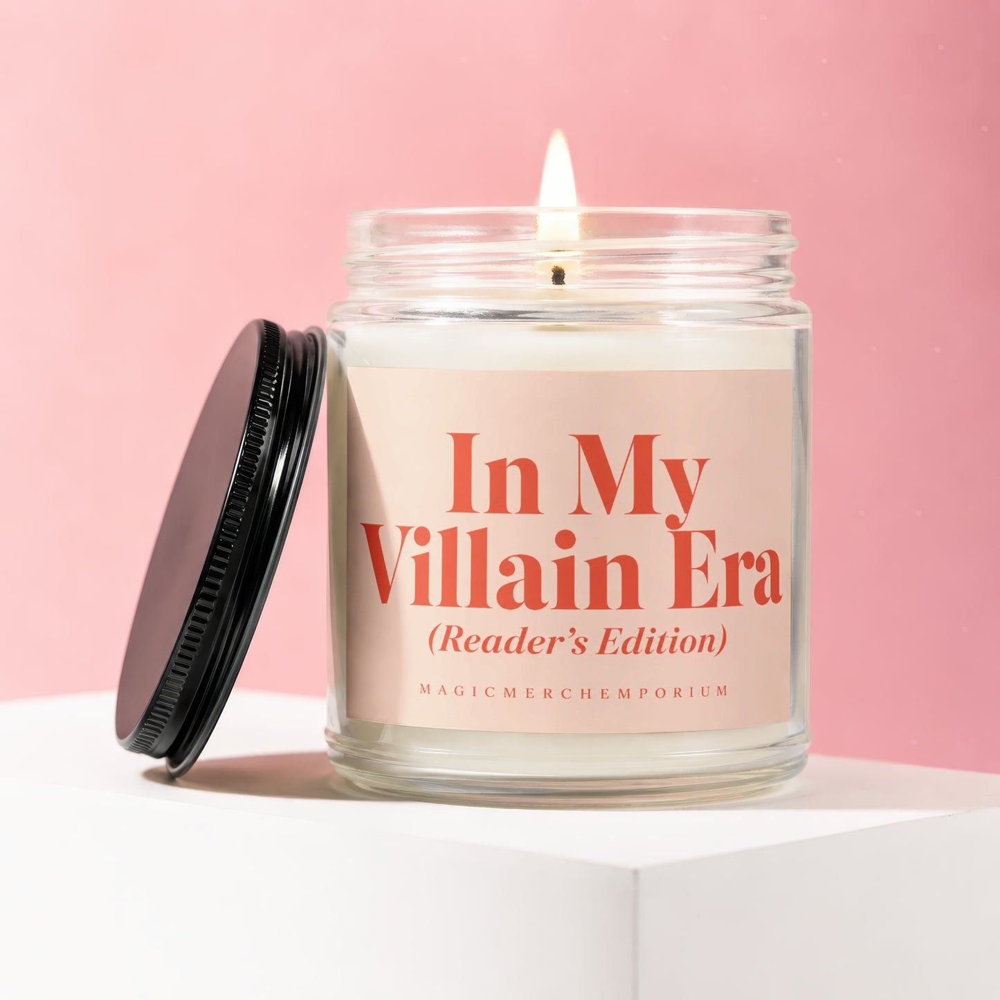 In My Villain Era (Reader's Edition) candle with flame on pink background.