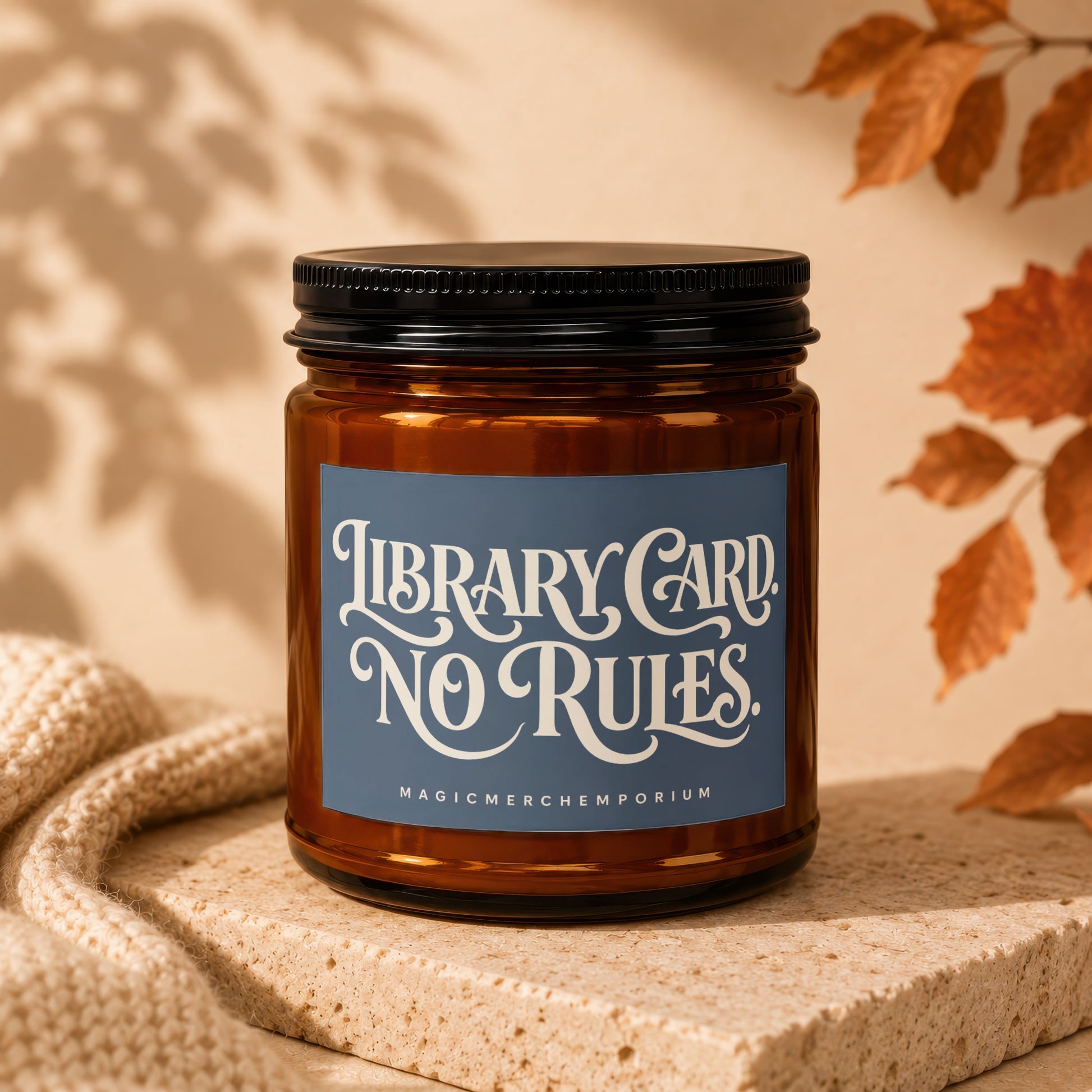 Amber candle in jar with blue label reading "Library Card. No Rules."