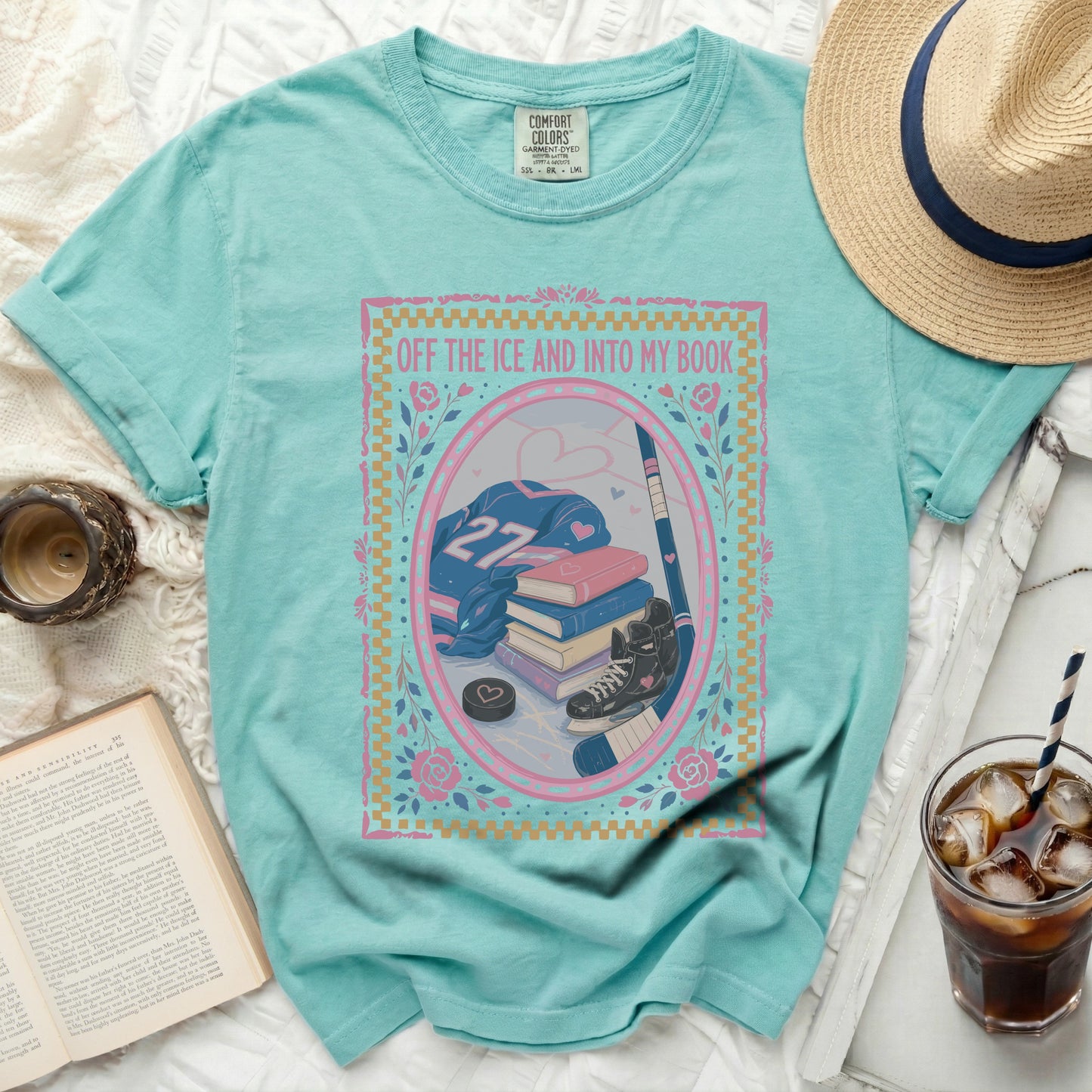 Turquoise t-shirt with "Off the Ice and Into My Book" and hockey gear.