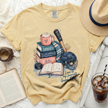 Yellow t-shirt with books, hockey gear, and text "Love is my favorite Game Plan".