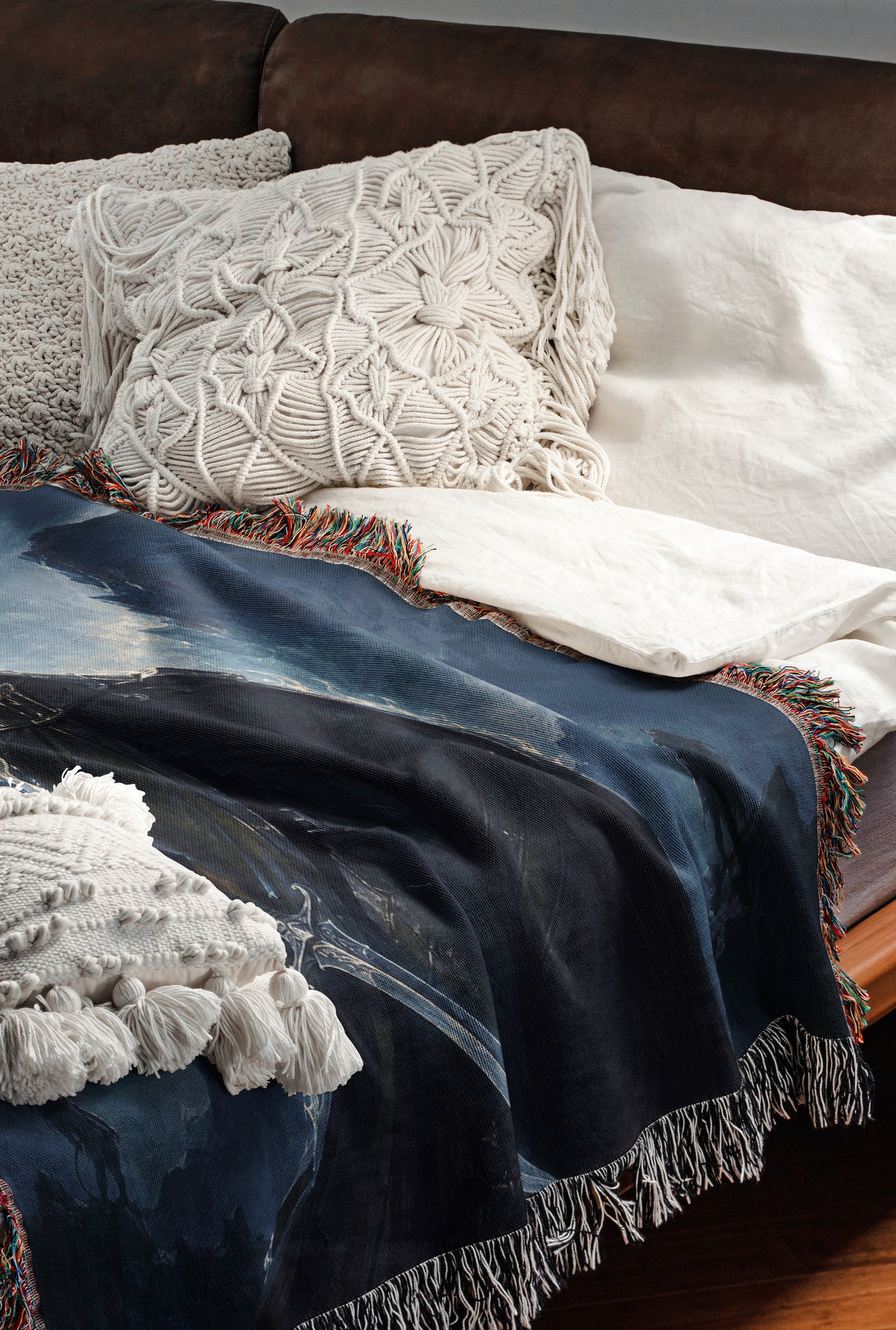 a cozy and inviting bedroom scene, featuring a comfortable bed with a blue blanket and white pillows, as well as a brown leather couch. The bed is adorned with a decorative throw blanket and a white shawl, adding to the overall warmth and comfort of the space.