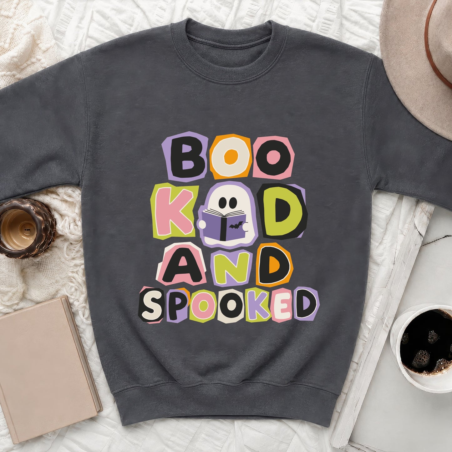 Dark grey sweatshirt with colourful text "Boo K'd And Spooked" and a reading ghost graphic.