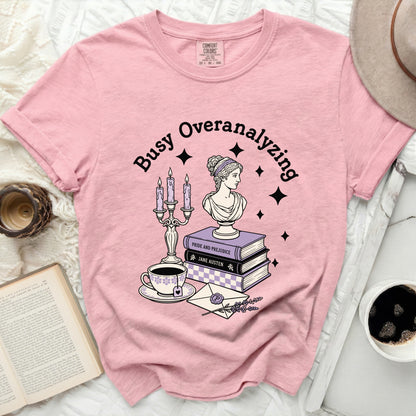 Pink t-shirt with "Busy Overanalyzing" graphic and literary elements.