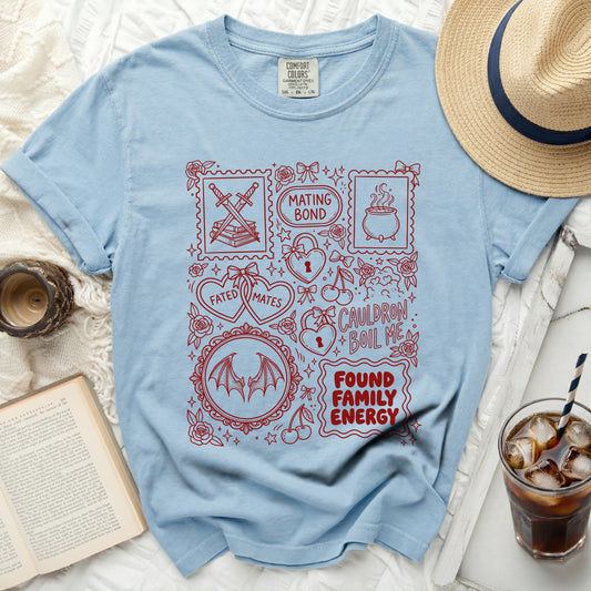 Light blue t-shirt with red graphic of stamps, hearts, and text.