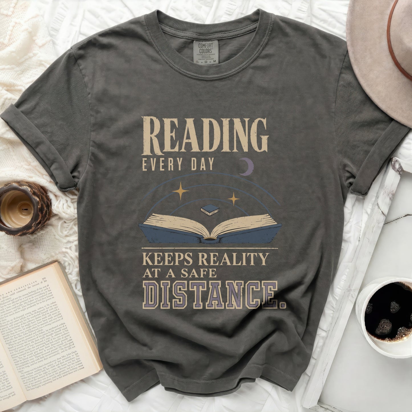 T-shirt with "Reading Every Day Keeps Reality At A Safe Distance" graphic.