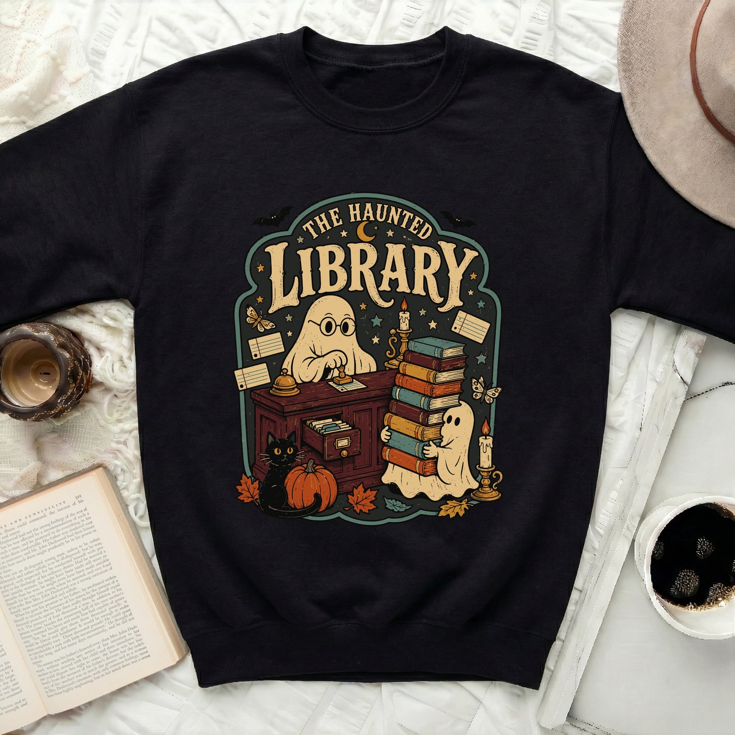 Black sweatshirt with "The Haunted Library" graphic featuring ghosts, cat, pumpkin, and books.
