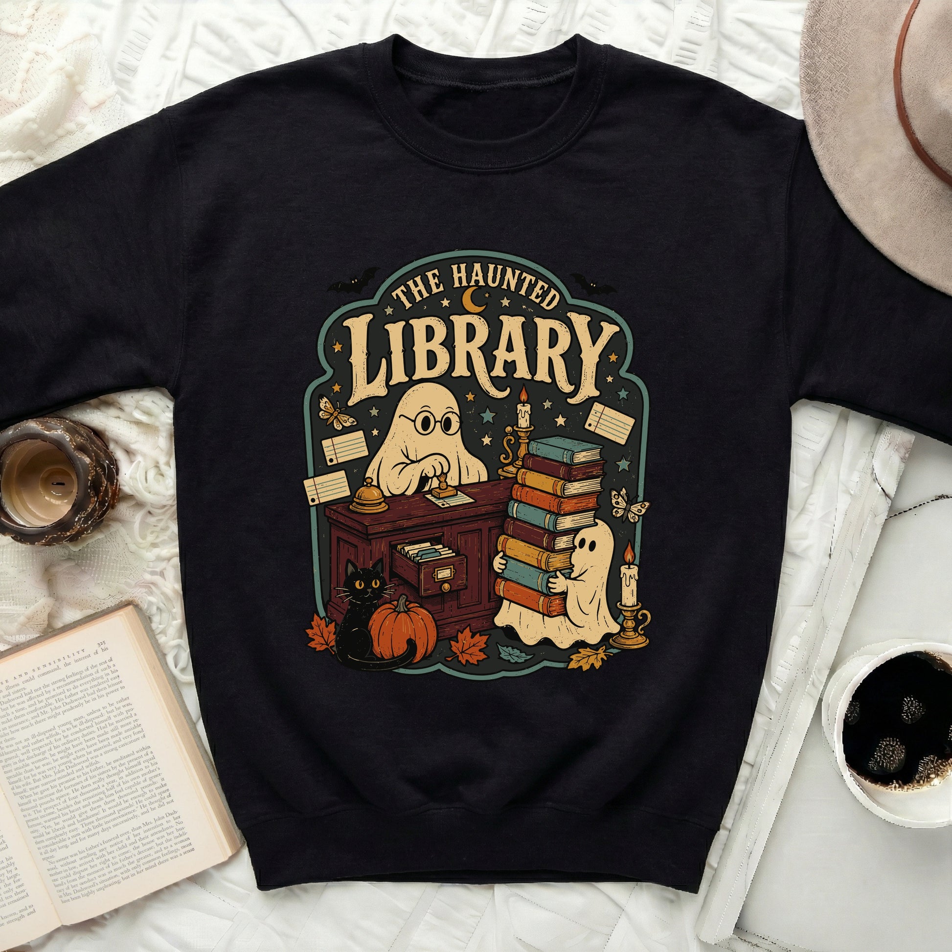 Black sweatshirt with "The Haunted Library" graphic featuring ghosts, cat, pumpkin, and books.