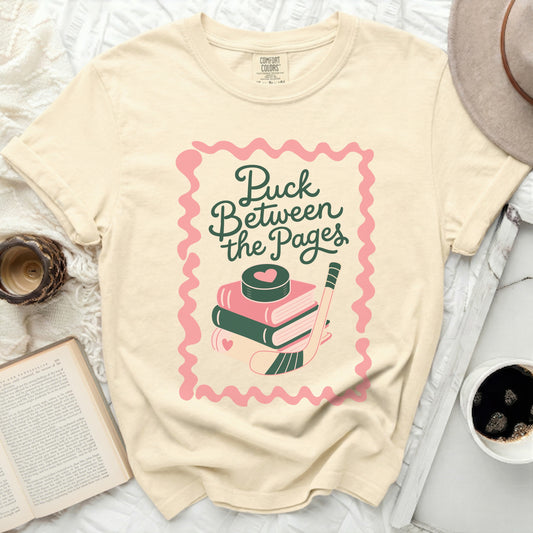 Cream t-shirt with "Puck Between the Pages" text and hockey puck.