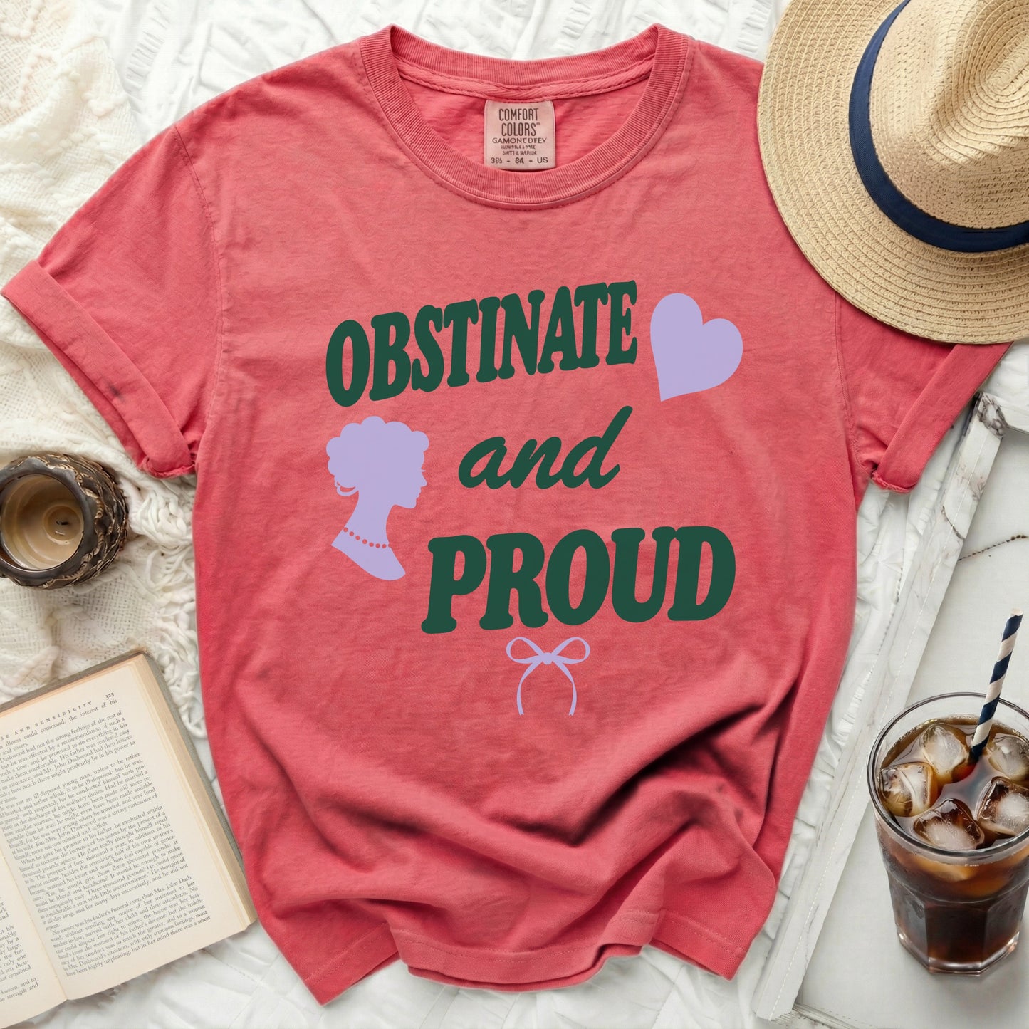 Coral t-shirt with green text "OBSTINATE and PROUD" and purple graphics.
