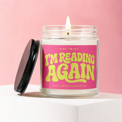 Glass jar candle with pink label reading "Plot Twist: I'm Reading Again"