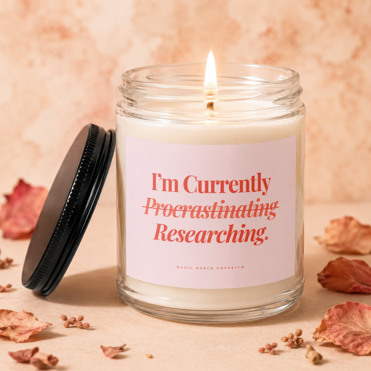 Glass candle with pink label reading "I'm Currently Procrastinating Researching."