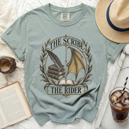 Light blue t-shirt with "The Scribe The Rider" graphic, feather, books, and dragon wing.