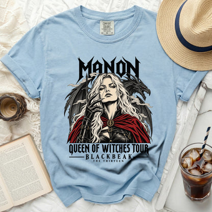Light blue t-shirt with "MANON QUEEN OF WITCHES TOUR BLACKBEAK THE THIRTEEN" graphic.