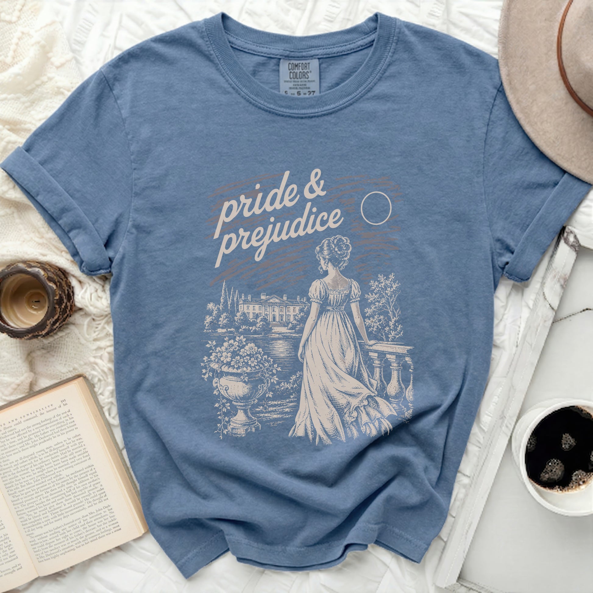 Blue t-shirt with "pride & prejudice" text and vintage illustration.