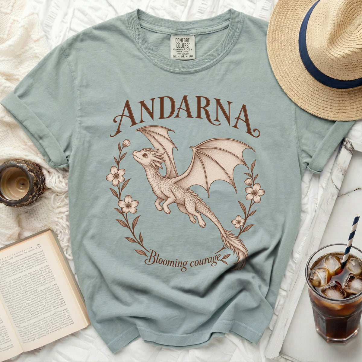 Light blue t-shirt with a dragon graphic and text "ANDARNA Blooming courage".