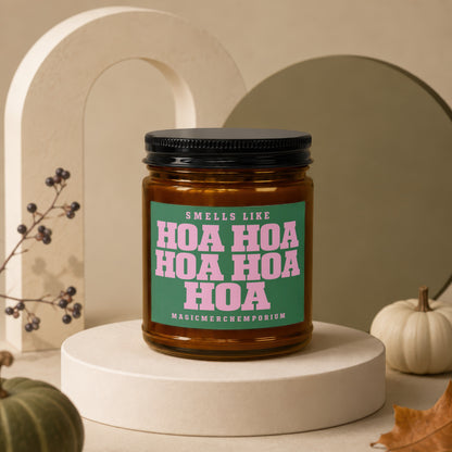 Amber jar candle with green label reading "Smells Like Hoa Hoa Hoa Hoa Hoa Hoa" and "MagicMerchEmporium".