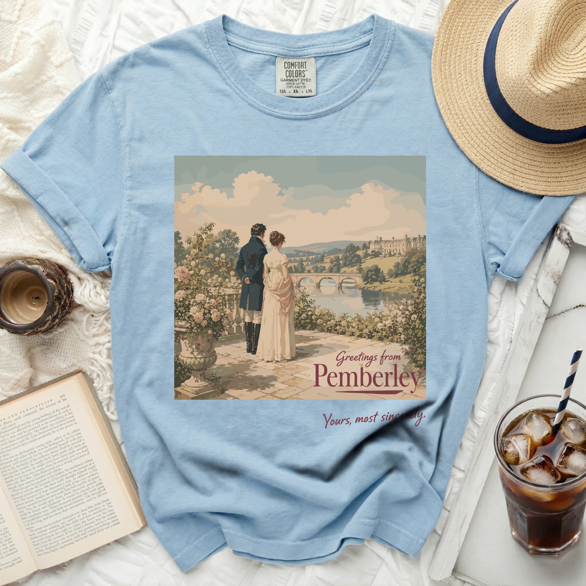 Light blue t-shirt with "Greetings from Pemberley" artwork and a couple.