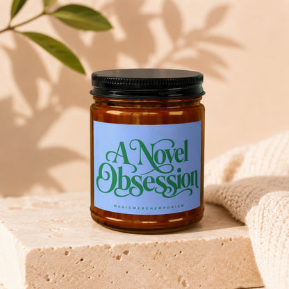 Amber candle in a jar with a blue label reading "A Novel Obsession".